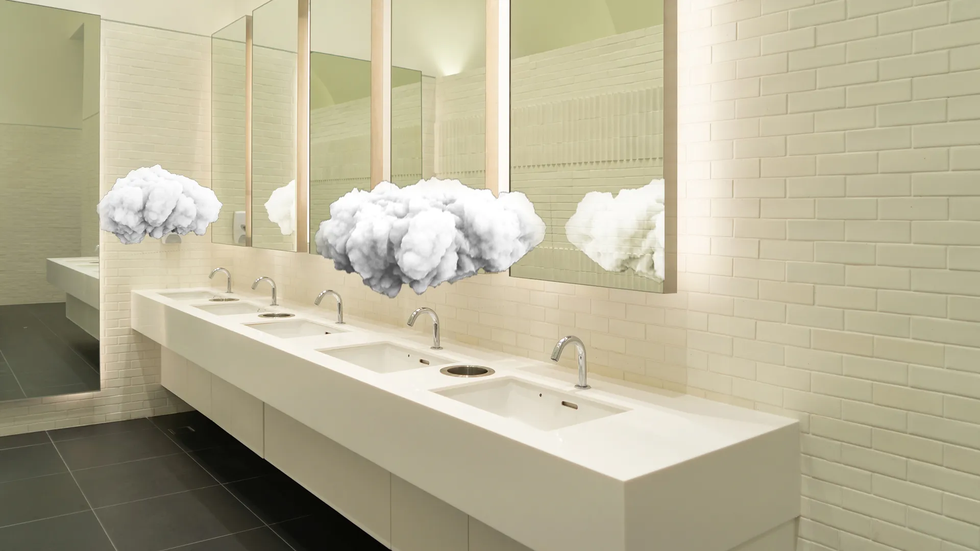 Modern public restroom with white sinks and chrome faucets, featuring surreal floating cloud sculptures in front of mirrors.
